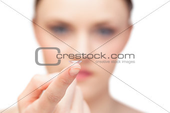 Beautiful nude model holding contact lens