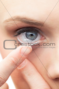 Beautiful model applying contact lens