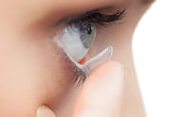 Extreme close up on young model applying contact lens