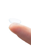 Extreme close up on finger holding contact lens