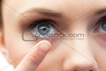 Extreme close up on gorgeous model applying contact lens