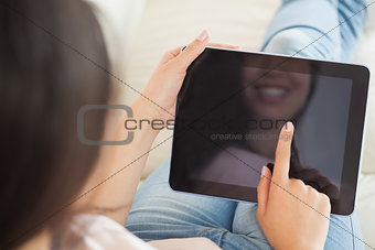 Girl using her tablet pc on the couch