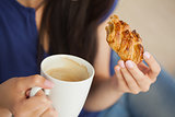 Woman having a pastry with a cup of coffee
