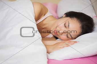 Peaceful young asian woman sleeping in her bed