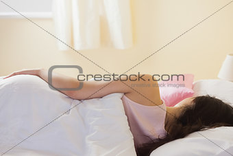 Rear view of woman lying in her bed