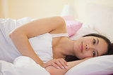 Young asian woman lying in her bed and thinking