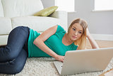 Woman lying on floor and using laptop