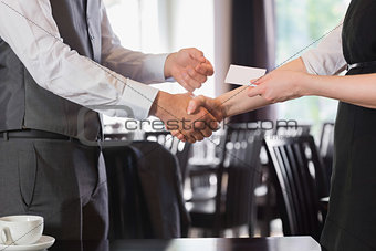 Busines people shaking hands after meeting and changing cards