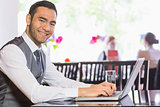 Smiling businessman working on laptop
