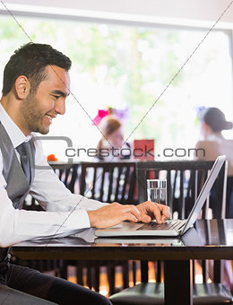 Smiling businessman looking at laptop screen