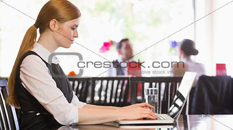 Concentrated businesswoman working on laptop