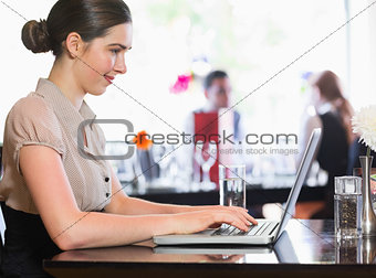 Smiling businesswoman looking at laptop screen