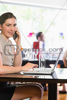 Smiling woman talking on phone looking at camera