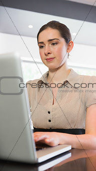 Confident businesswoman working on laptop