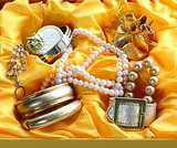 gold jewelry and pearls in a yellow gift box