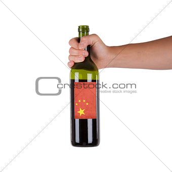 Hand holding a bottle of red wine