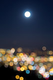 Full Moon Rise Over Blurred City Lights