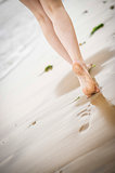 Woman's legs walking along the beach