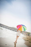 Woman walking along the beach with an umbrella