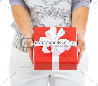 Closeup on christmas present box giving by young woman