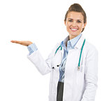 Smiling doctor woman presenting something on empty palm