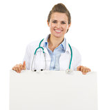 Smiling doctor woman showing blank billboard