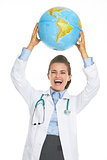 Happy doctor woman showing earth globe