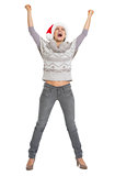 Happy young woman in sweater and christmas hat rejoicing