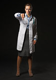 Full length portrait of doctor woman showing thumbs down on blac