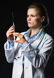 Doctor woman using syringe on black background