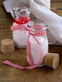 strawberry yogurt in glass jars on a wooden table