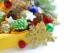 Christmas decorations (balls, cones, stars) in the yellow box