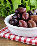 ripe black kalamata olives in a white bowl