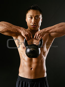Asian man exercising with kettlebell