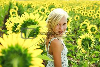 Dreamy young girl in the field of sunflowers