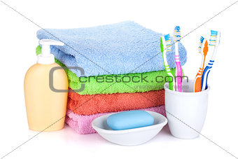 Four colorful toothbrushes, soap and towels