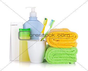 Toothbrushes, cosmetics bottles and two towels