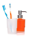 Two colorful toothbrushes and liquid soap