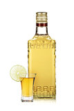 Bottle of gold tequila and shot with lime slice
