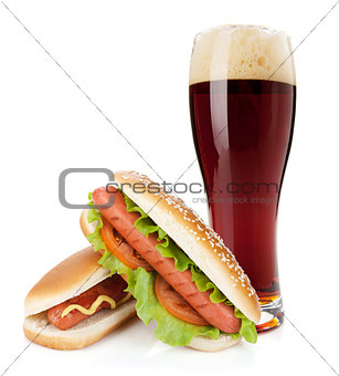 Dark beer glass and two hot dogs with various ingredients