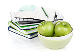 Green apples in fruit bowl and office supplies