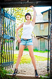Girl posing in the gate of the old house.