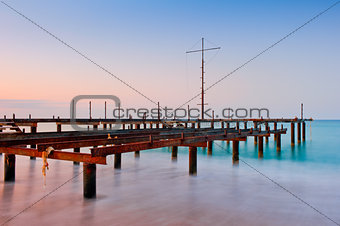 Old pier in the sea at dawn