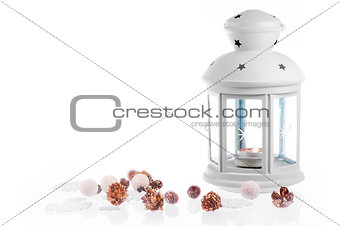 White lantern candle with decorative Christmas elements