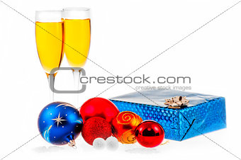 Two glasses of champagne, christmas balls and gift.