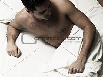 sleepless Man sitting in a bed pensive insomnia sadness