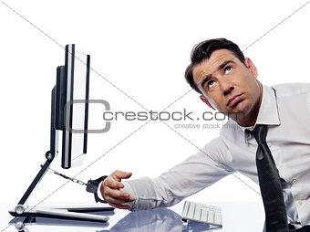 Man chained to computer with handcuffs sad
