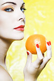 Woman portrait showing a orange tangerine fruit
