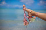 Woman leg hold pink bra isolated on exotic background