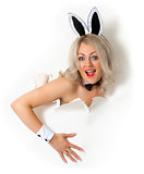 Cheerful girl in bunny suit looking out of hole